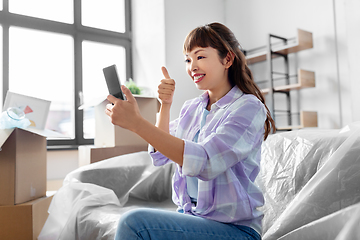 Image showing woman with phone having video call at new home