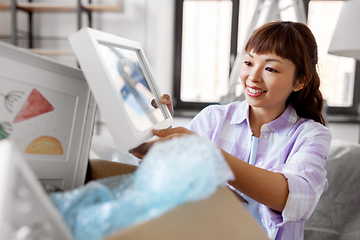 Image showing happy woman unpacking boxes and moving to new home