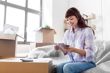 Image showing asian woman moving to new home and counting money