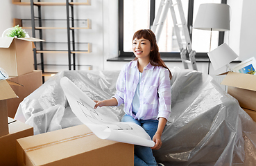 Image showing woman with blueprint and boxes moving to new home