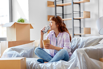 Image showing happy woman moving to new home and eating wok