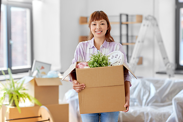 Image showing happy woman unpacking boxes and moving to new home