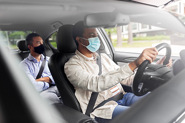 Image showing male driver in mask driving car with passenger