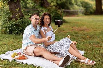 Image showing happy couple taking selfie at picnic in park