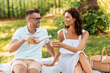 Image showing happy couple with wine having picnic at park