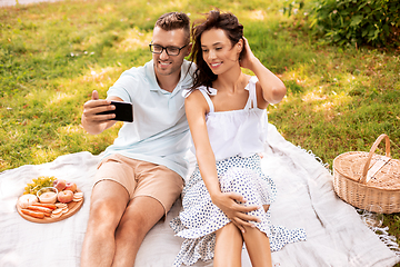 Image showing happy couple taking selfie at picnic in park