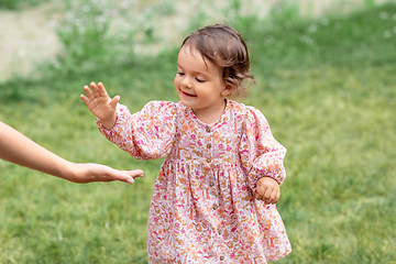 Image showing happy smiling baby girl giving hand to adult