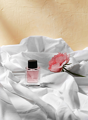 Image showing bottle of perfume and flower on white sheet