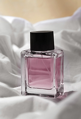 Image showing bottle of perfume on white sheet