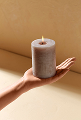 Image showing hand holding burning aroma candle on palm