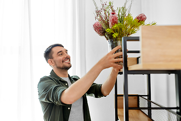 Image showing man decorating home with flowers in vase