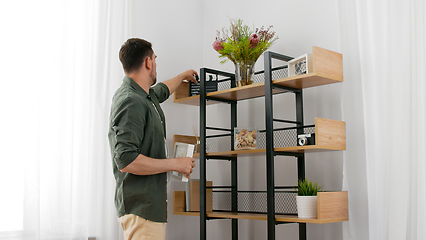 Image showing man decorating home and arranging shelf