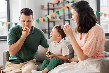 Image showing happy family with gifts and party blowers at home