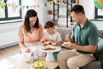 Image showing happy family eating birthday cake at home party