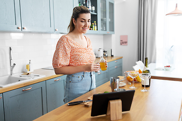 Image showing woman with tablet pc making cocktails at kitchen