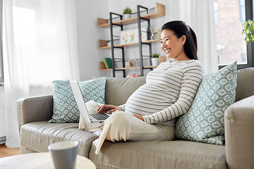 Image showing happy pregnant asian woman with laptop at home