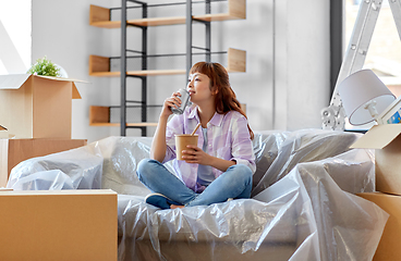 Image showing happy woman moving to new home and eating wok