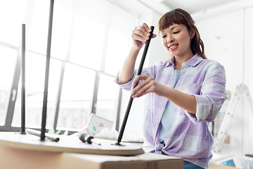 Image showing happy woman assembling coffee table at new home