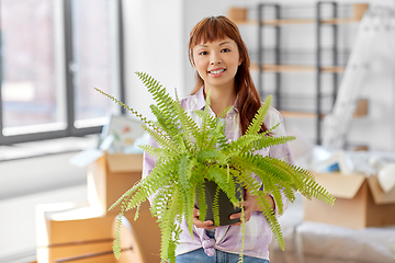 Image showing happy woman with fern flower moving to new home