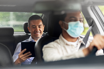 Image showing passenger with tablet pc and car driver in mask