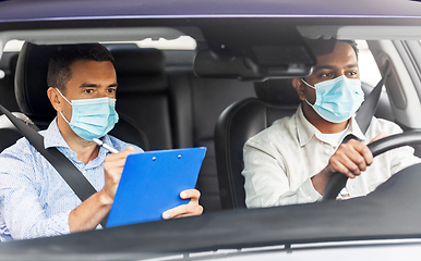 Image showing car driving school instructor and driver in mask