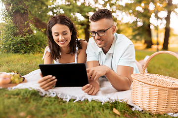 Image showing happy couple with tablet pc at picnic in park