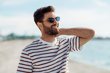 Image showing smiling young man in sunglasses on summer beach