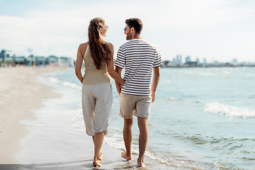 Image showing happy couple walking along summer beach