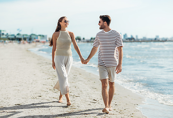 Image showing happy couple walking along summer beach