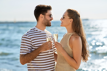 Image showing happy couple drinking champagne on summer beach