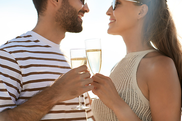 Image showing happy couple drinking champagne on summer beach