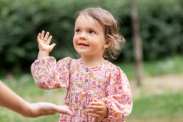 Image showing happy smiling baby girl giving hand to adult