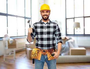 Image showing happy male builder in helmet with hammer at home