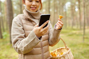 Image showing asian woman using smartphone to identify mushroom