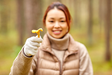 Image showing young asian woman with mushroom in autumn forest