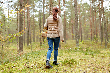 Image showing young woman picking mushrooms in autumn forest