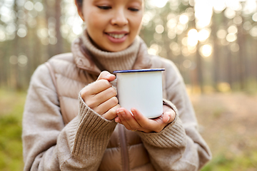 Image showing asian woman with mug drinking tea in forest