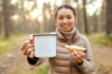 Image showing asian woman with mug drinking tea in forest