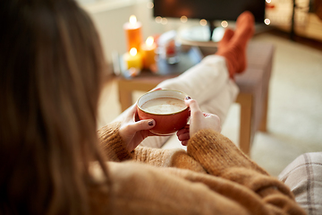 Image showing woman watches tv and drinks cocoa on halloween