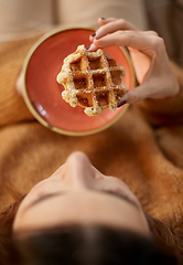 Image showing close up of woman eating waffle at home