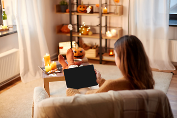 Image showing woman with tablet pc at home on halloween