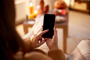 Image showing woman using smartphone at home on halloween