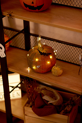 Image showing halloween pumpkin with garland lights on shelf