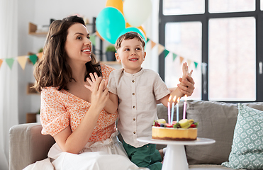 Image showing happy mother and son with birthday cake at home