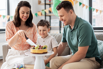 Image showing happy family with birthday cake at home