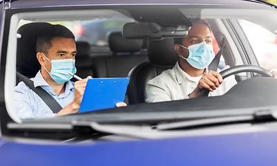 Image showing car driving school instructor and driver in mask