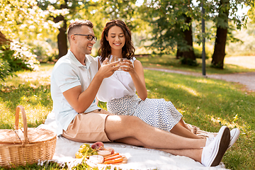 Image showing happy couple having picnic at summer park