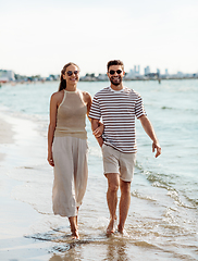 Image showing happy couple walking along summer beach