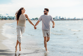 Image showing happy couple running along summer beach