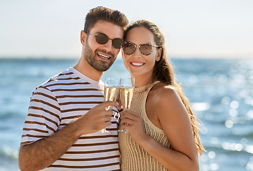 Image showing happy couple drinking champagne on summer beach